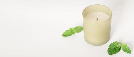 soy wax candle with mint leaves, copy space, banner. home fragrance, aromatherapy and relaxation at house photo