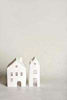 paper houses on light grey background. real estate and development concept. Mortgage insurance and relocation. photo