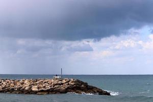 Breakwater on the city beach for protection from high sea waves. photo