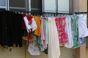 Washed linen dries on the street outside the window of the house. photo