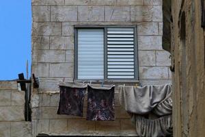 Washed linen dries on the street outside the window of the house. photo