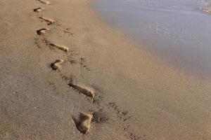 Footprints in the sand on the city beach. photo