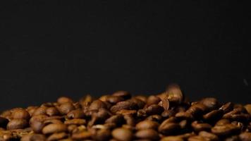 rallentatore di chicchi di caffè tostati che cadono. semi di caffè biologico. video