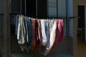 Washed linen dries on the street outside the window of the house. photo