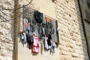 Washed linen dries on the street outside the window of the house. photo