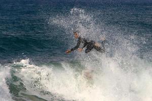 December 21, 2018 Israel. Surfing on high waves in the Mediterranean. photo