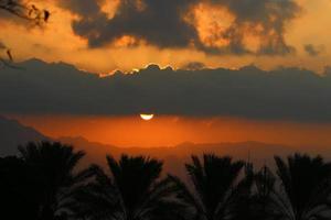 amanecer en el mar muerto en israel. el sol sale de detrás de las montañas en jordania. foto