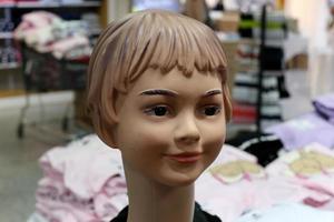 A mannequin stands on a showcase in a store. photo