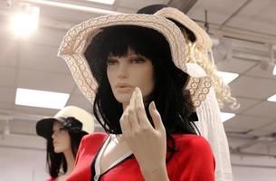 A mannequin stands on a showcase in a large store. photo