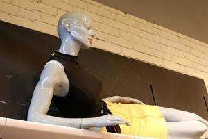 A mannequin stands on a showcase in a large store. photo