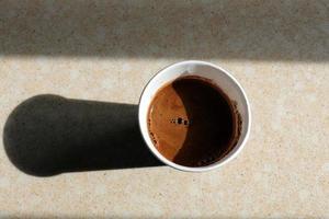 Hot and strong coffee is poured into a cup. photo