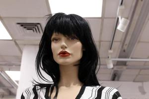 A mannequin stands on a showcase in a store. photo