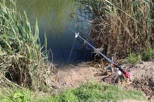 Fishing rod on the shore of the lake. photo