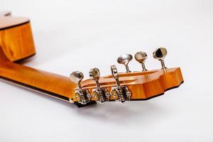 Tuning pegs on wooden machine head of six strings guitar on white background photo
