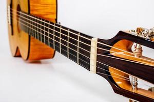 Tuning pegs on wooden machine head of six strings guitar on white background photo