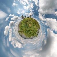 Little planet transformation of spherical panorama 360 degrees. Spherical abstract aerial view in field with awesome beautiful clouds. Curvature of space. photo