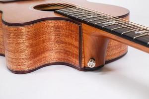 wood texture of lower deck of six strings acoustic guitar on white background. guitar shape photo