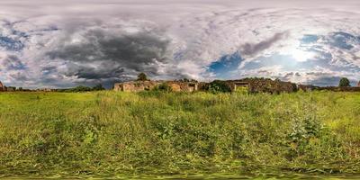 Full spherical seamless hdri panorama 360 degrees angle view near walls of abandoned ruined stone farm building with beautiful clouds in equirectangular projection, VR AR virtual reality content. photo