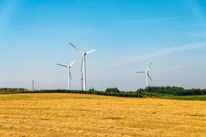 rotating blades of a windmill propeller on blue sky background. Wind power generation. Pure green energy. photo