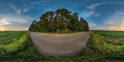 vista de ángulo de 360 grados de panorama hdri esférico completo sin costuras en camino de grava entre campos en la puesta de sol de la tarde de verano con nubes impresionantes en proyección equirectangular, contenido de realidad virtual listo vr ar foto