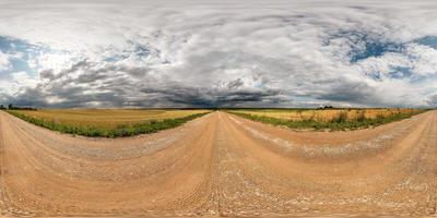 panorama hdri esférico completo sin costuras vista en ángulo de 360 grados en camino de grava entre campos con impresionantes nubes antes de la tormenta en proyección equirectangular, listo para contenido de realidad virtual vr ar foto