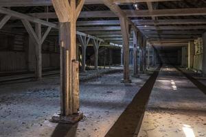 inside dark abandoned ruined wooden decaying hangar with rotting columns photo