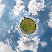 Little planet transformation of spherical panorama 360 degrees. Spherical abstract aerial view in field in nice day with awesome beautiful clouds. Curvature of space. photo