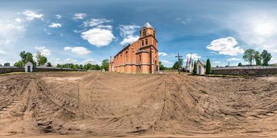 Full seamless hdri panorama 360 degrees angle view red brick facade of church in decorative medieval neo gothic style architecture in small village in equirectangular spherical projection. vr content photo