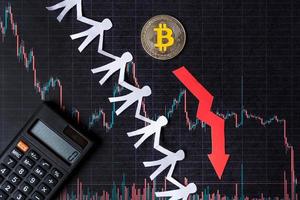 unprofitable investment of depreciation of virtual money bitcoin. red arrow, silver bitcoin and paper crowd go down on paper forex chart index background. Concept of depreciation of cryptocurrency. photo