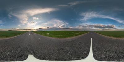 vista de ángulo de 360 grados de panorama hdri esférico sin costuras en carretera asfaltada entre campos en la puesta de sol de la tarde de verano con nubes impresionantes en proyección equirectangular, contenido de realidad virtual listo vr ar foto