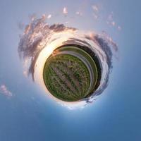 pequeño planeta transformación de panorama esférico 360 grados. vista aérea abstracta esférica en el campo en una agradable velada con impresionantes nubes hermosas. curvatura del espacio. foto