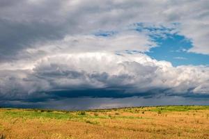 hdr panorama on gravel road among fields in evening with awesome black clouds before storm photo