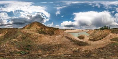 full seamless hdri panorama 360 degrees angle view near quarry flooded with water for sand extraction mining with awesome clouds in equirectangular spherical projection for VR AR content photo