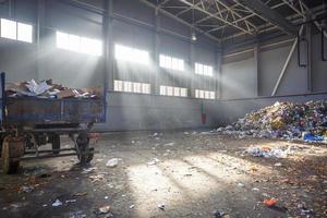 trash sorting and recycling workshop with trailer at the waste processing plant with sun rays. Separate garbage collection. Recycling and storage of waste for further disposal. photo