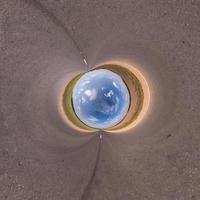 blue sky ball in middle of swirling asphalt road or field. Inversion of tiny planet transformation of spherical panorama 360 degrees. Spherical abstract view. Curvature of space. photo