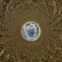 blue sky ball in middle of swirling field. Inversion of tiny planet transformation of spherical panorama 360 degrees. Curvature of space. photo