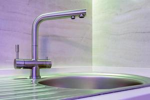 Water tap sink with faucet in expensive loft kitchen with neon light photo