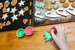 Handmade decorating of festive gingerbread cookies in the form of stars, snowflakes, people, socks, staff, mittens, Christmas trees, hearts for xmas and new year holiday. preparation for holidays photo