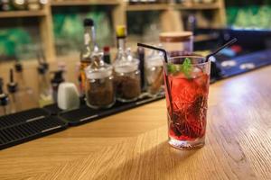 ready red alcohol cocktail on background bars of spices in an elite bar for making cocktails Cinnamon Rosehip Clove Drunk Cherry photo