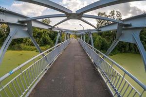 iron steel frame construction of pedestrian bridge across the river photo