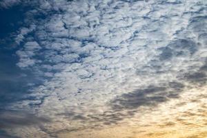 Blue sky background with tiny curly rolling clouds in the evening. Clearing day and Good windy weather photo