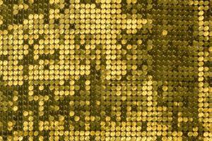 rows of blinking golden yellow brass metal plaques sway in wind and shines in sun and create unique pattern of movement. round reflective particles texture glitter under waves of wind. Spangle Glitter photo