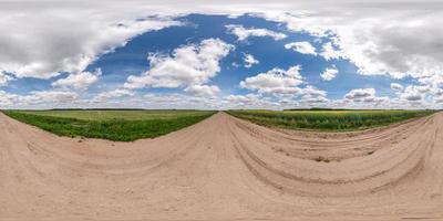 vista de ángulo de 360 grados de panorama hdri esférico completo en camino de grava entre campos en el día de verano con nubes impresionantes en proyección equirectangular, para contenido de realidad virtual vr ar foto