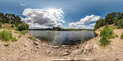 full spherical seamless hdri panorama 360 degrees angle view on rocky shore of huge river in sunny summer day and windy weather with beautiful clouds in equirectangular projection, VR content photo