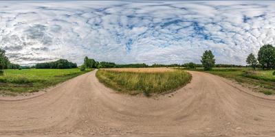 vista de ángulo de 360 grados de panorama hdri esférico completo entre campos en la puesta de sol de la tarde de verano con hermosas nubes en proyección equirectangular foto