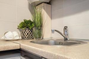 water tap sink with faucet in expensive kitchen photo