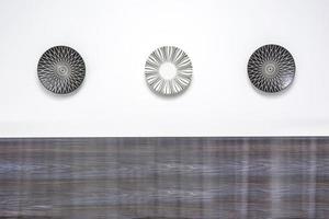 three painted plates on a white wall in modern apartments photo
