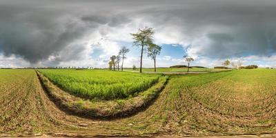 panorama esférico completo sin fisuras vista en ángulo de 360 grados cerca de la carretera de asfalto entre los campos de pradera después de la tormenta con impresionantes nubes en proyección equirectangular, vr ar contenido de realidad virtual foto