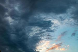 Blue sky background with evening fluffy curly rolling altocumulus altostratus clouds with setting sun. Good windy weather photo