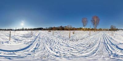 panorama esférico completo y transparente de 360 por 180 grados de ángulo de visión en el campo cubierto de nieve en el soleado día de invierno con halo en proyección equirectangular, skybox vr contenido de realidad virtual foto